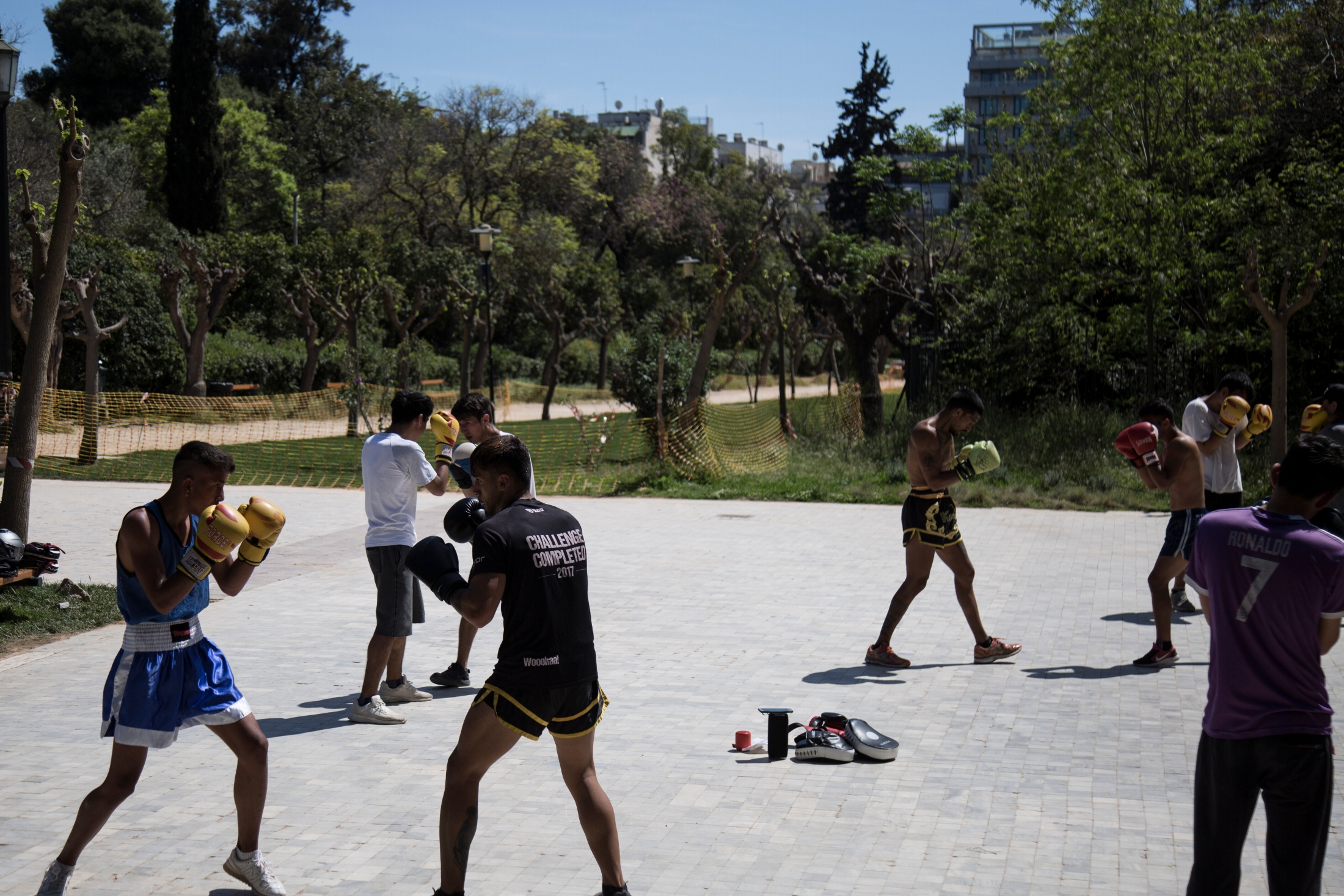 Mehrere junge Menschen trainieren in einem Athener Park Kampfsport