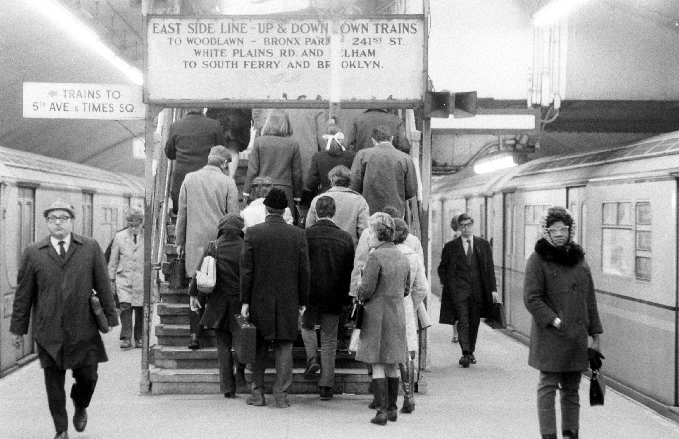 People walking up stairs at commuter train station in New York City,