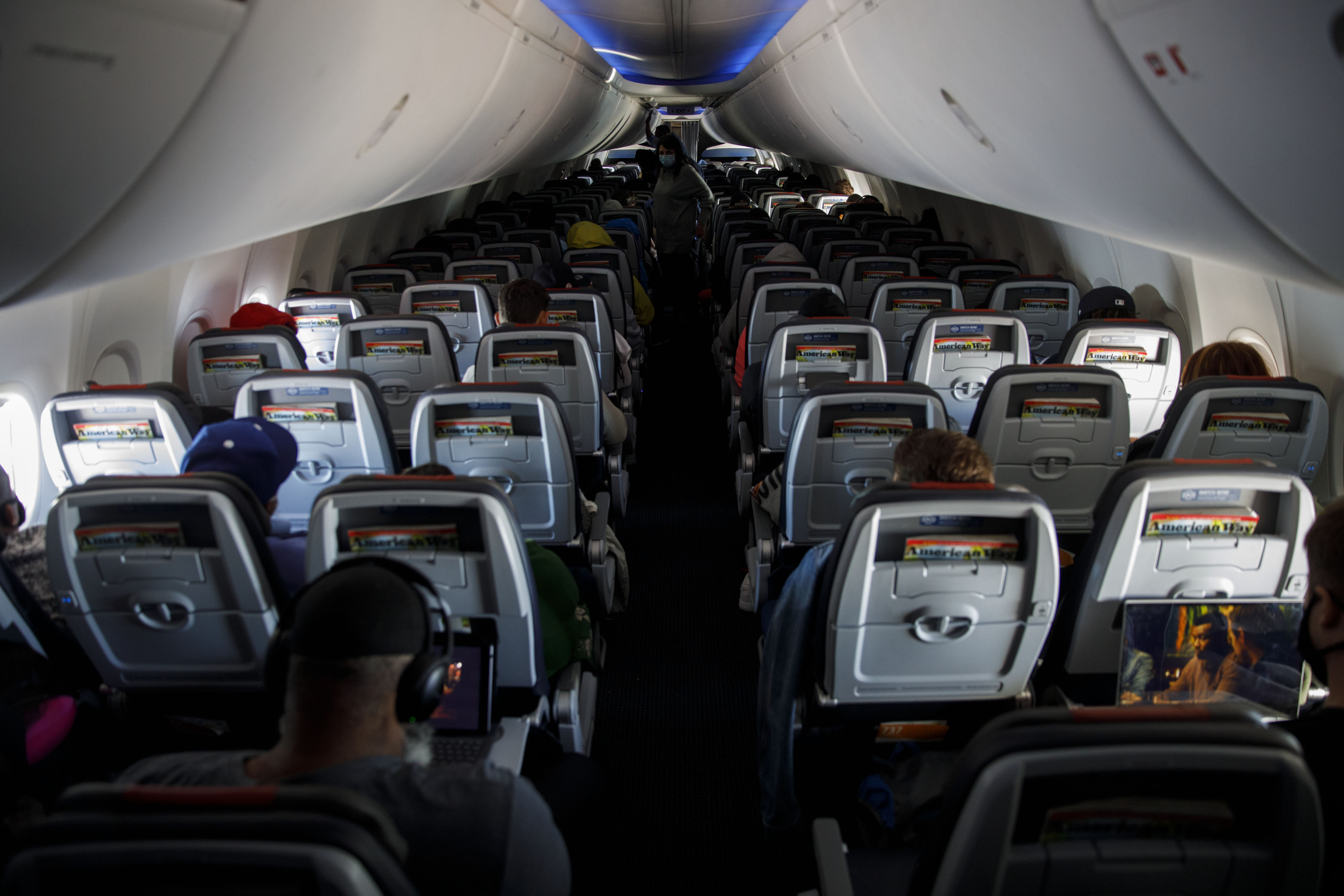 Passengers wear protective masks sit on a Boeing Co. 737-800 during an American Airlines Group Inc. flight