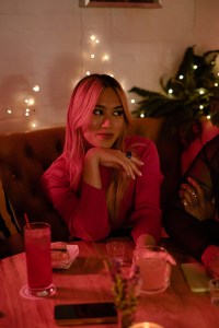 A transfeminine person hanging out with friends at a bar