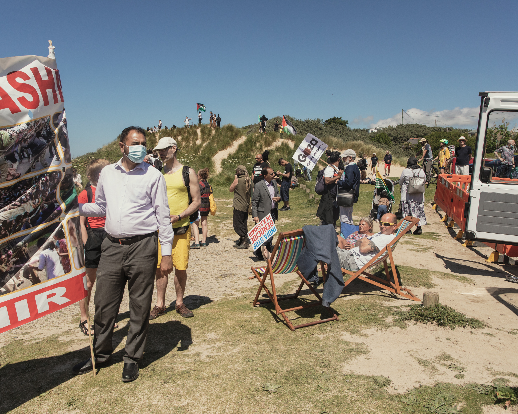 The group reaches the sand dunes looking over Hayle Beach, surrounding a couple of holidaymakers.