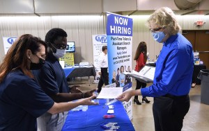 A man hands his resume to an employer at the 25th annual Central Florida Employment Council Job Fair at the Central Florida Fairgrounds. More than 80 companies were recruiting for over a thousand jobs. Organizers expected a couple thousand job seekers, bu