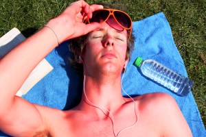 Sunburned man in aviator sunglasses squints at the sun.