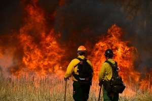 U.S. Fish and Wildfire firefighter Joe Murphy, left, and Denver firefighter Jordan Smith, right, keep an eye on the fire along the road during prescribed burn at the Rocky Mountain Arsenal National Wildlife Refuge on April 5, 2021 in Denver, Colorado.(Hel