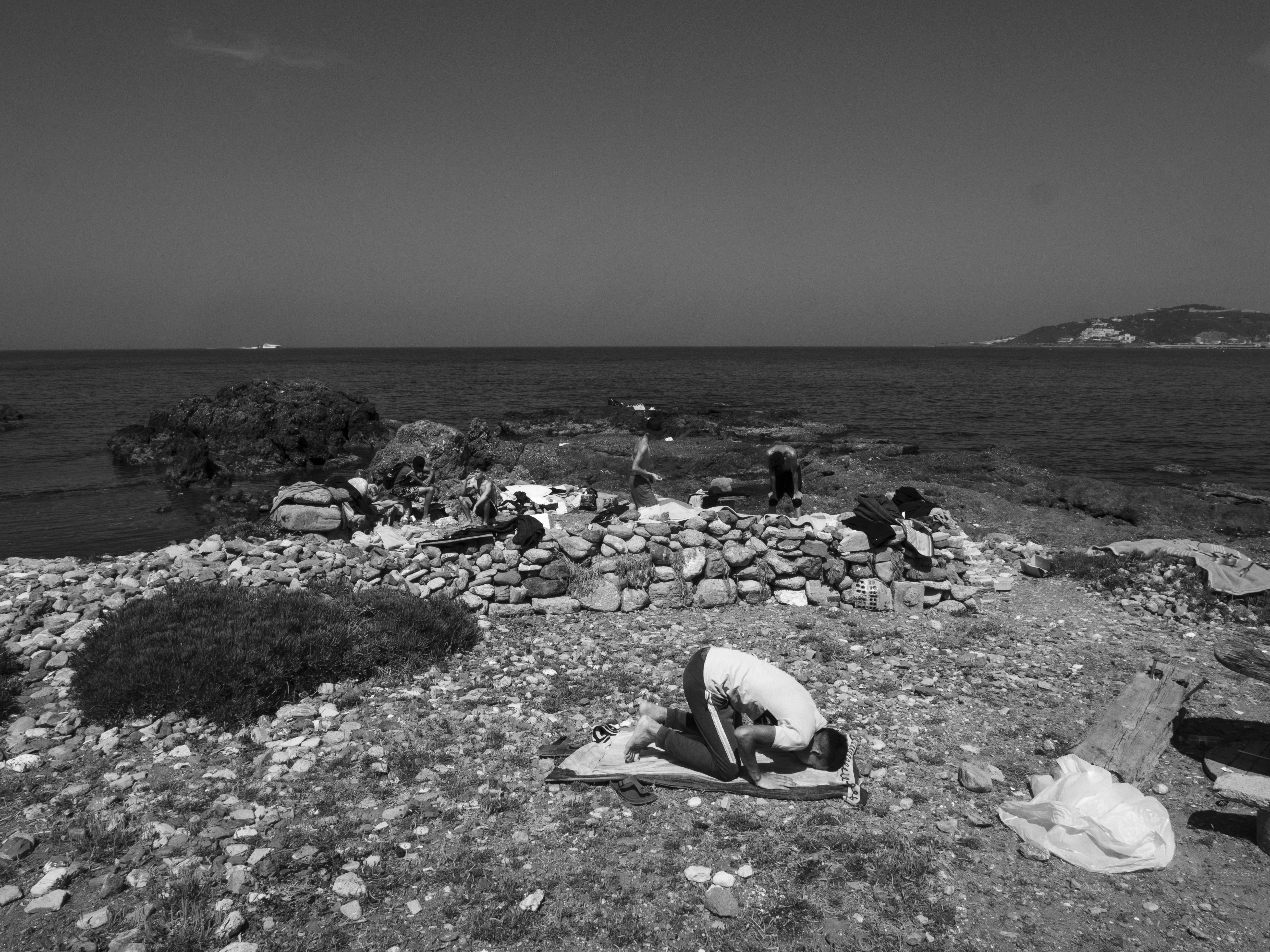Hervé Lequeux, Ceuta – Een jonge man bidt naast zijn geïmproviseerde kamp, bij het strand Benitez.