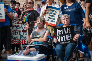 Attendees hold up signs at a rally at the state Capitol on June 20, 2021 in Austin, Texas.