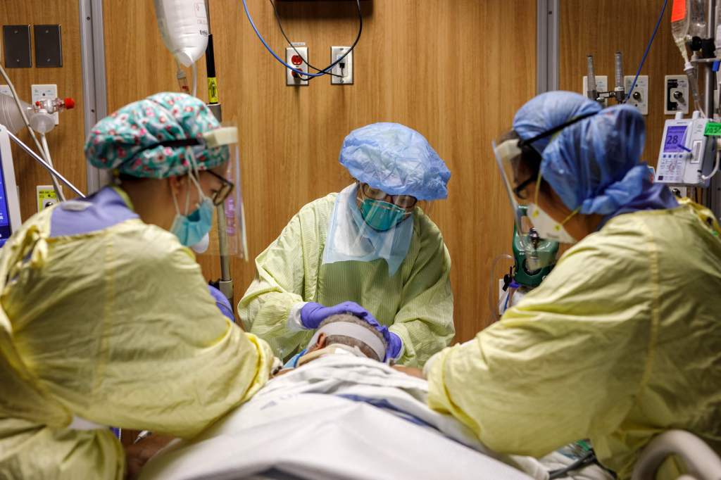 Respiratory Therapist Flor Guevara adjusts ventilator tubes as healthcare workers reposition a patient suffering from coronavirus disease (COVID-19) at Humber River Hospital's Intensive Care Unit, in Toronto, Ontario, Canada, on April 29, 2021. (Cole Burs