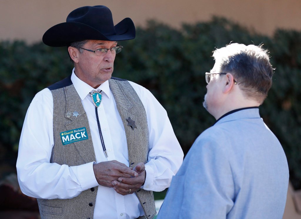 Richard Mack speaks with a constituent during the meeting of the state committee of the Arizona Republican Party, Saturday, Jan. 27, 2018 in Phoenix.