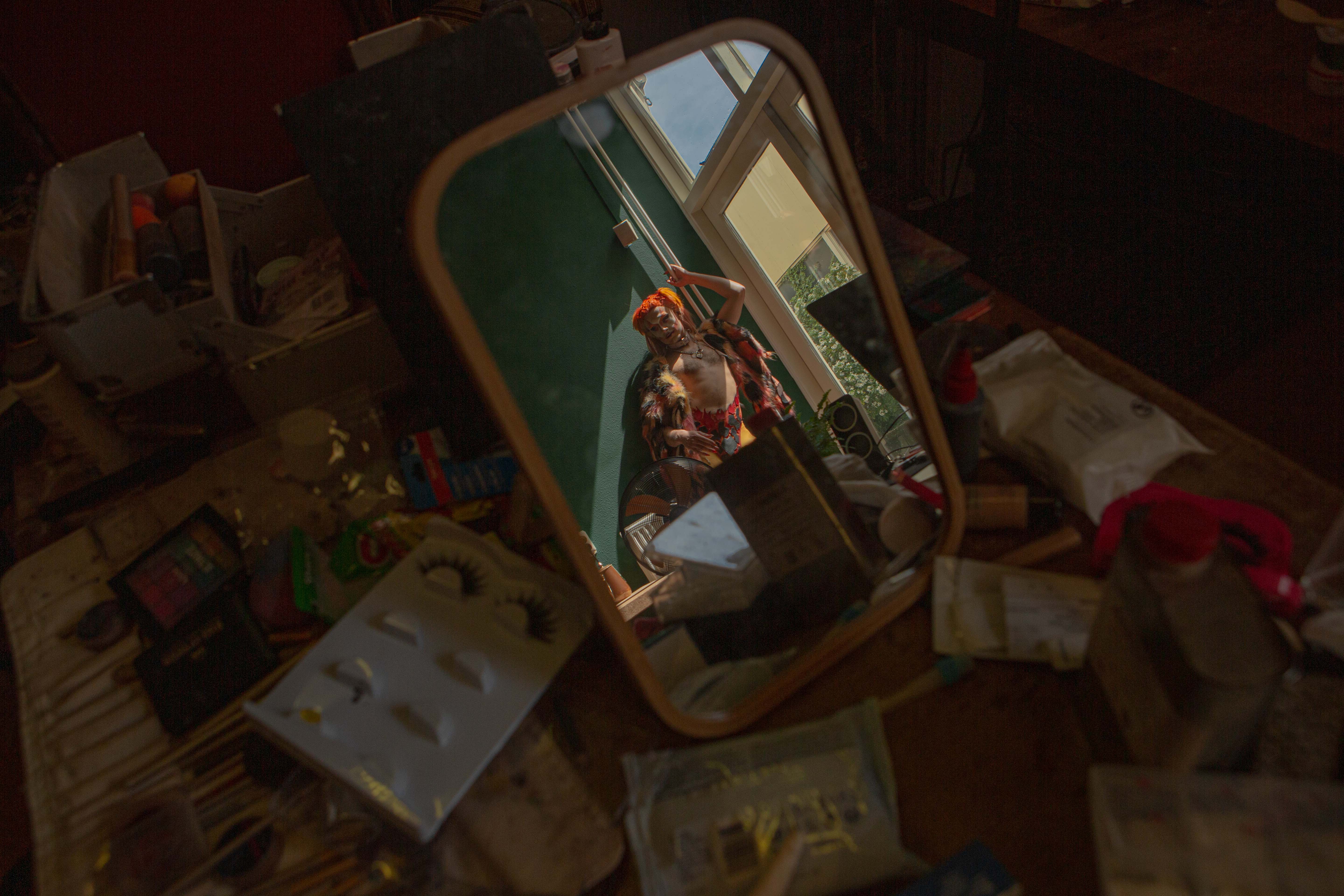 Alain Chaney, Sasa Hara, Queer Arcana – Character reflected in a mirror placed on top of a table full of make up