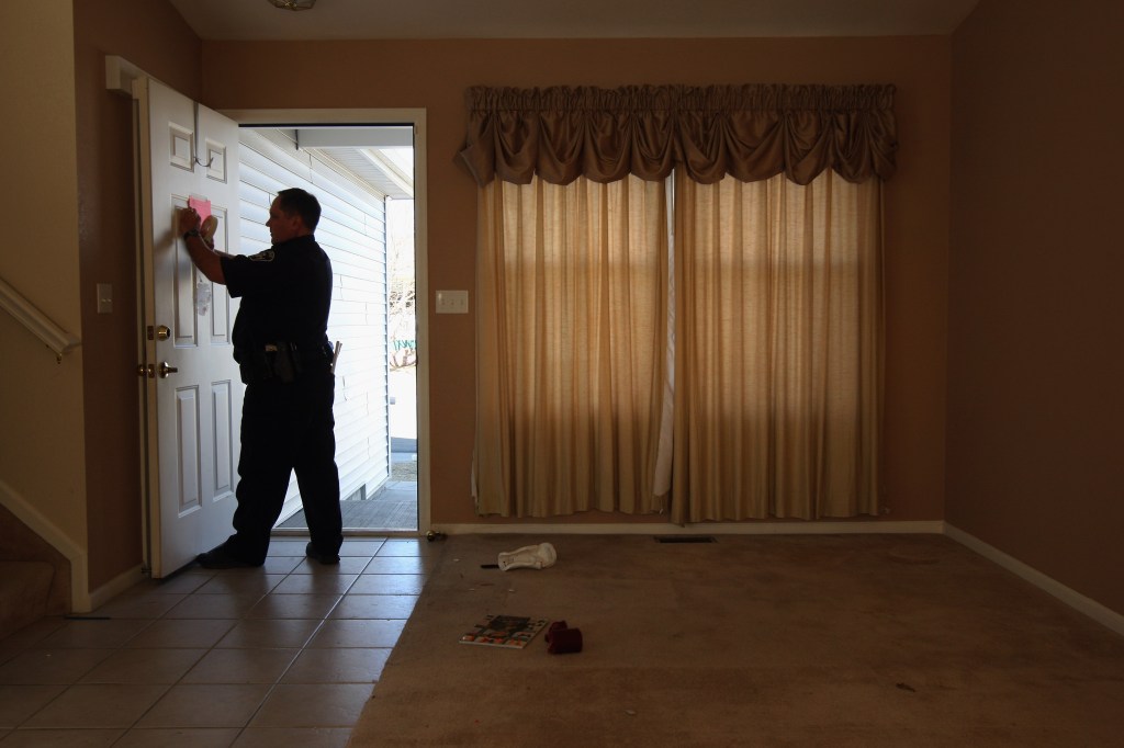 A sheriff's deputy tapes a "no trespass order" on the front door of a home that was forclosed February 18, 2009.