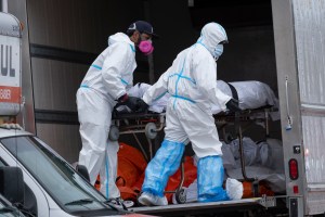 Workers move bodies to a refrigerated truck in the Brooklyn borough of New York, Wednesday, April 29, 2020.