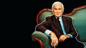 Loriot sitzt auf einem edel-bürgerlichen Sofa. Es wird Zeit, dass wir Loriot canceln, weil er alte Stereotype reproduziert und damit die Macht des Alten Weißen Mannes stärkt.