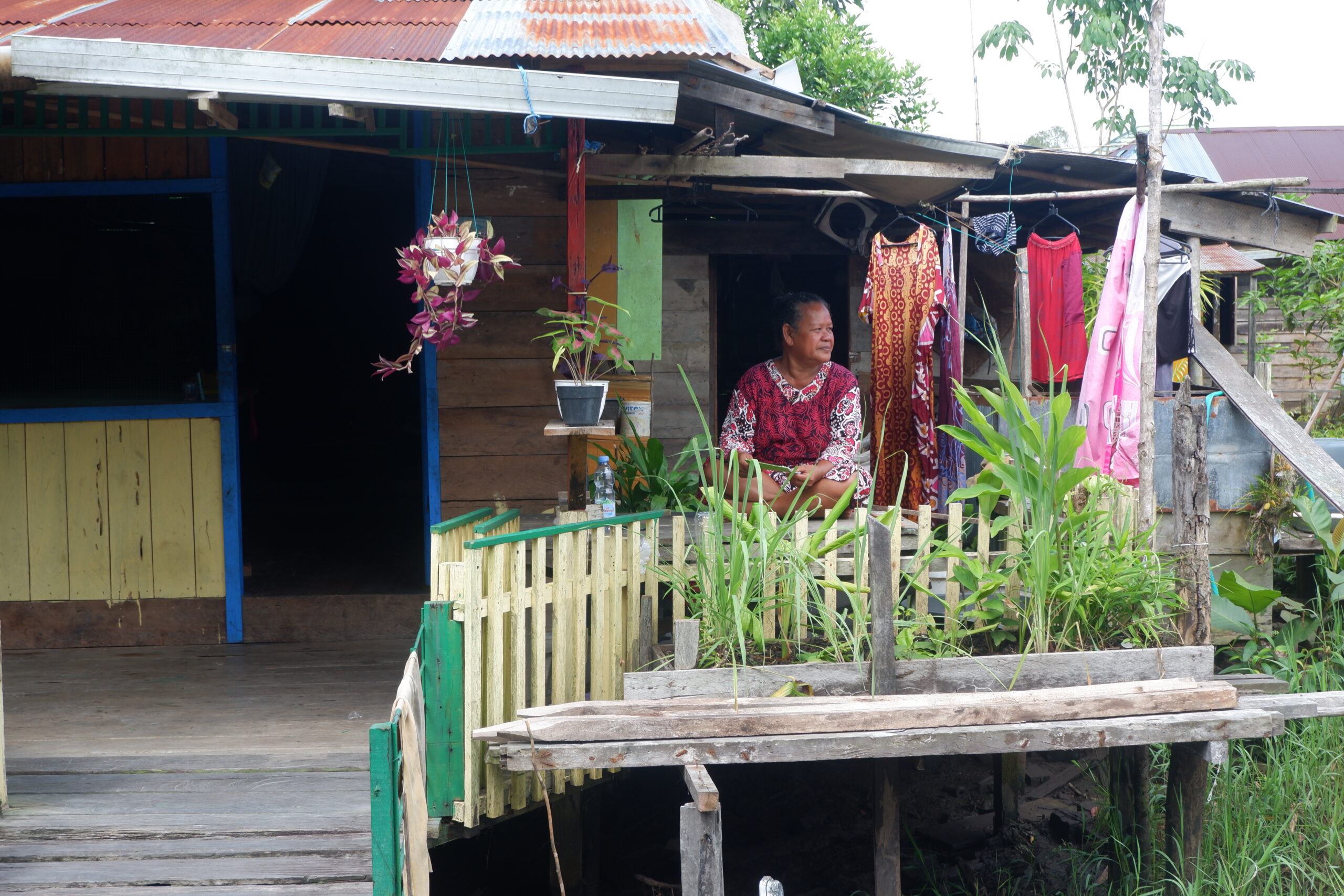 Jumiati duduk di teras rumahnya, di depannya adalah kebun mungil miliknya yang berisi sayur dan bermacam empon-empon untuk bumbu memasak (VICE_TitahAW) (1).JPG