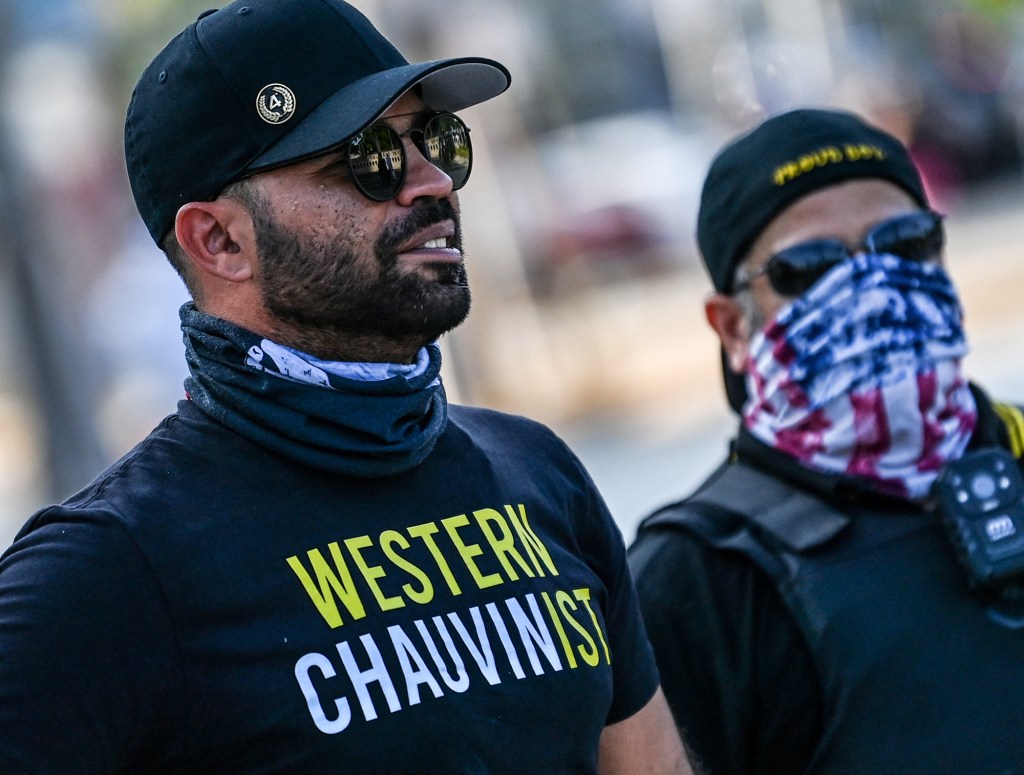 Chairman of the Proud Boys Enrique Tarrio (L) looks on while counter-protesting near the Torch of Friendship, where people gathered to remember George Floyd on the one-year anniversary of his murder at the hands of a police officer, in Miami on May 25, 20