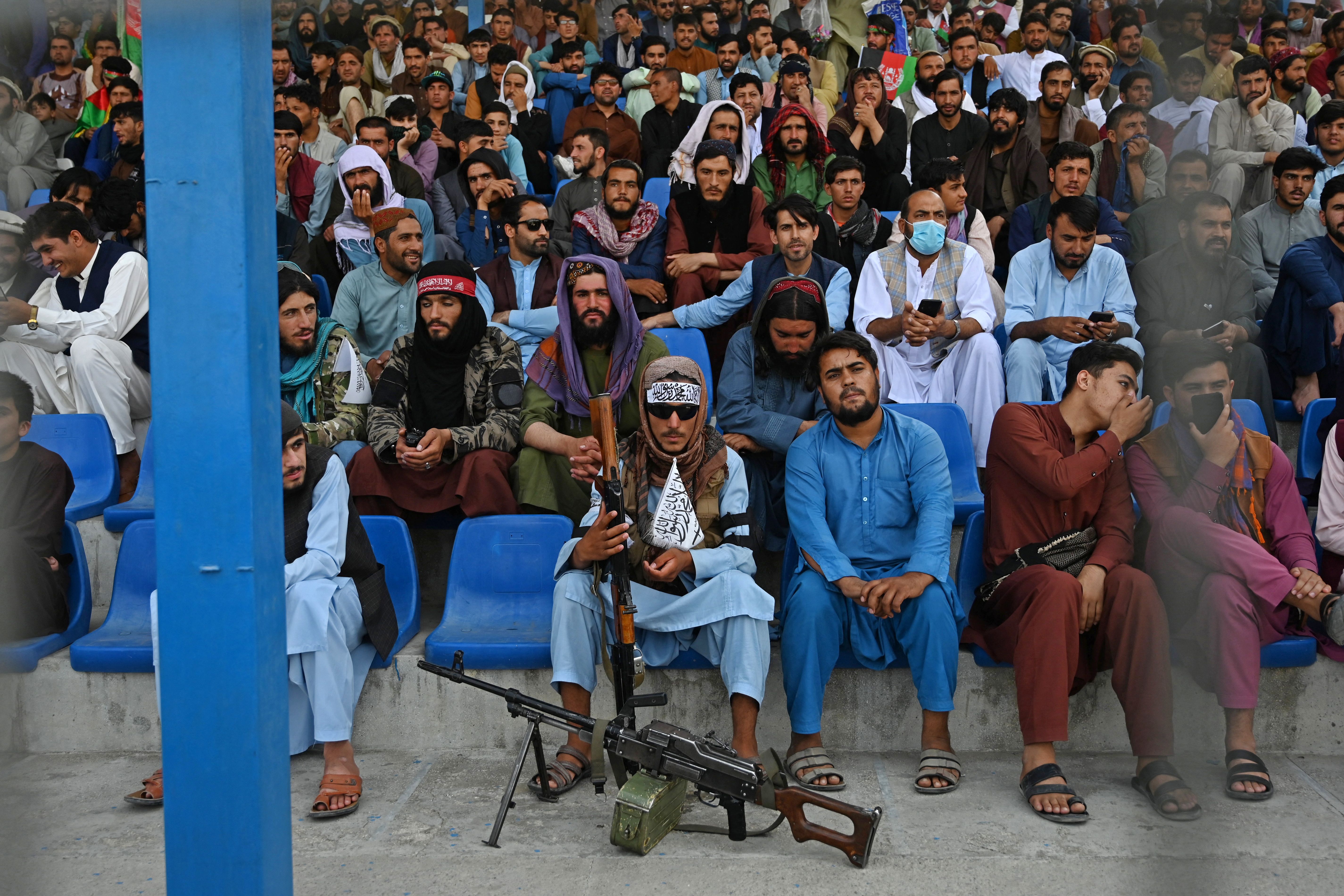 A Taliban fighter sits as spectators watch a Twenty20 cricket match between two Afghan teams in Kabul in early September. Photo: AAMIR QURESHI/AFP via Getty Images