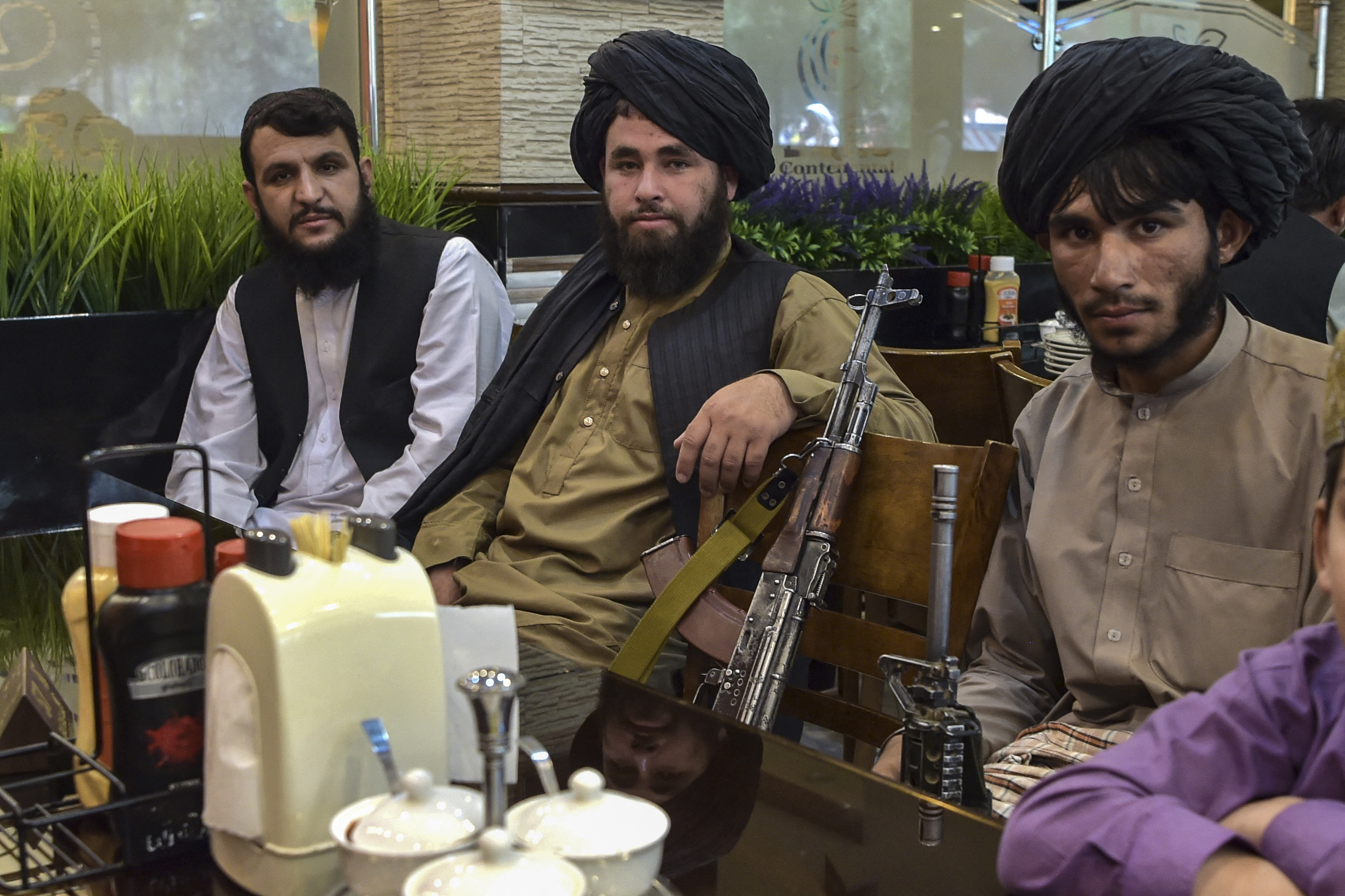 Taliban fighters wait for their meals at a restaurant in Kabul in last August. Photo: WAKIL KOHSAR/AFP via Getty Images