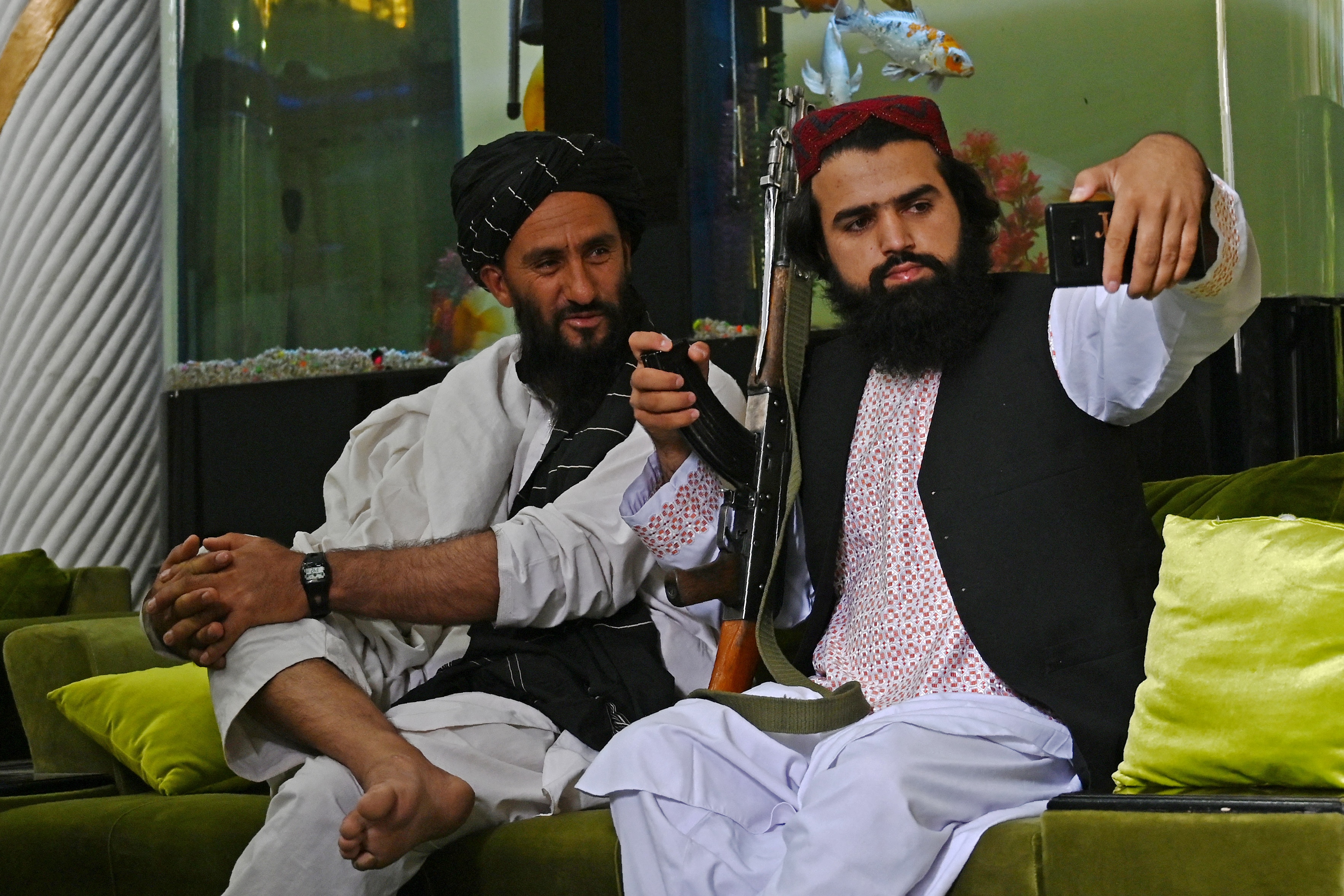 Taliban fighters take a selfie against the backdrop of Afghan warlord Abdul Rashid Dostum's aquarium, having taken over his mansion in Kabul. Photo: WAKIL KOHSAR/AFP via Getty Images