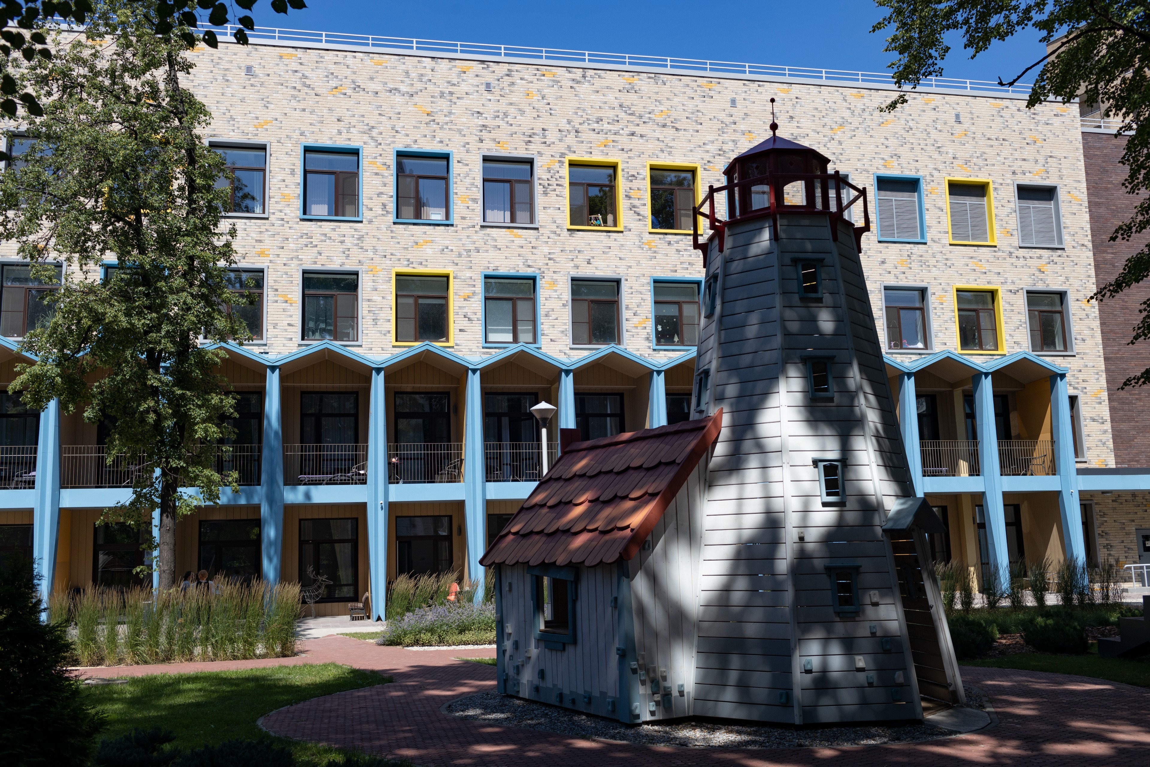 Ein Leuchtturmmodell zum spielen vor einem gelb und blau angestrichenen Gebäude