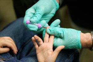 In this Jan. 26, 2016, file photo, registered nurse Brian Jones draws a blood sample from a student at Eisenhower Elementary School in Flint, Michigan.
