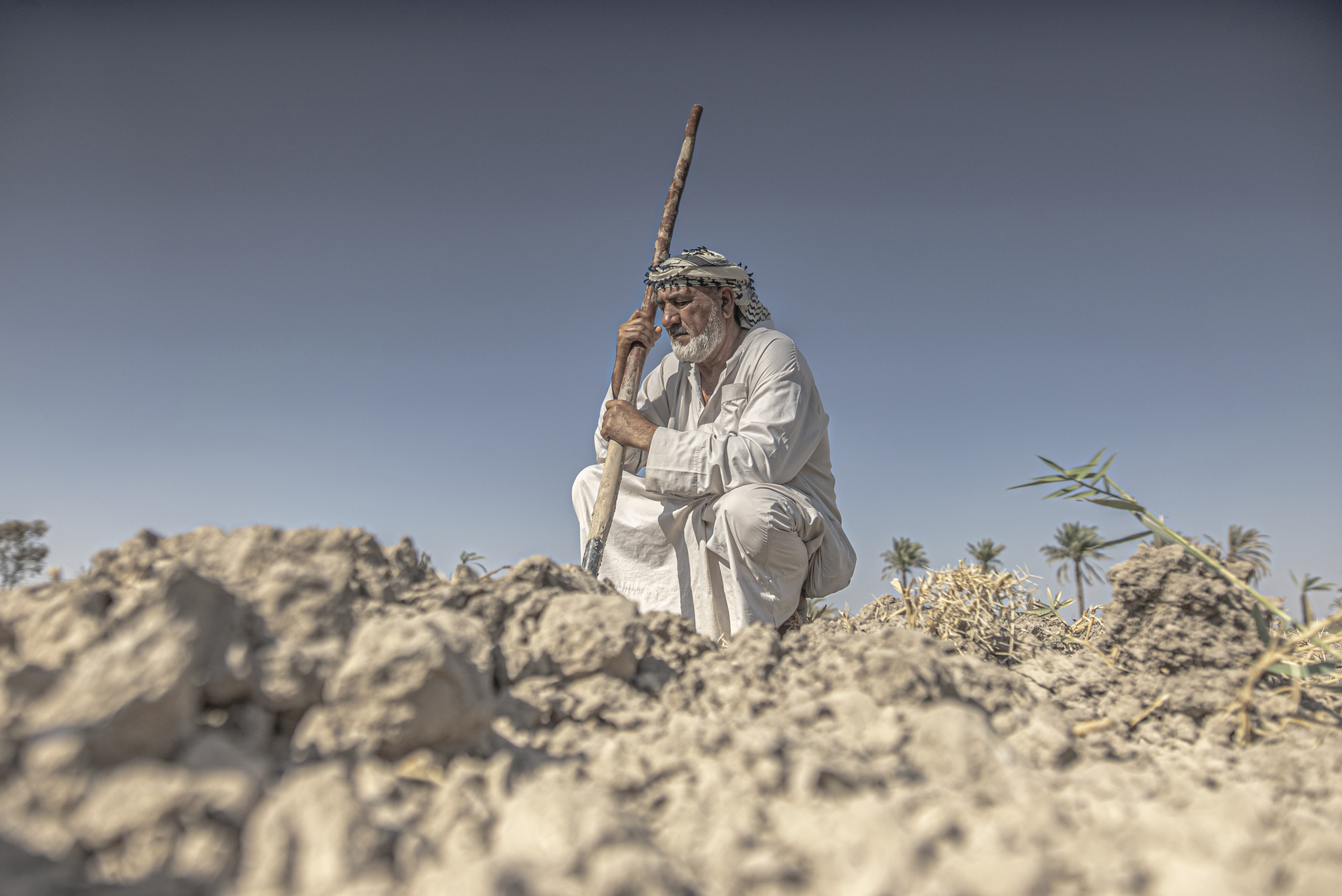 Climate crisis, Iraq - Photograph of man in traditional headscarf holding a staff.