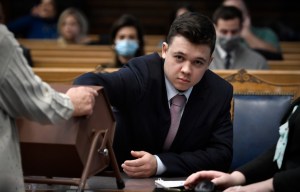 Kyle Rittenhouse pulls numbers of jurors out of a tumbler during his trial at the Kenosha County Courthouse on November 16, 2021 in Kenosha, Wisconsin.