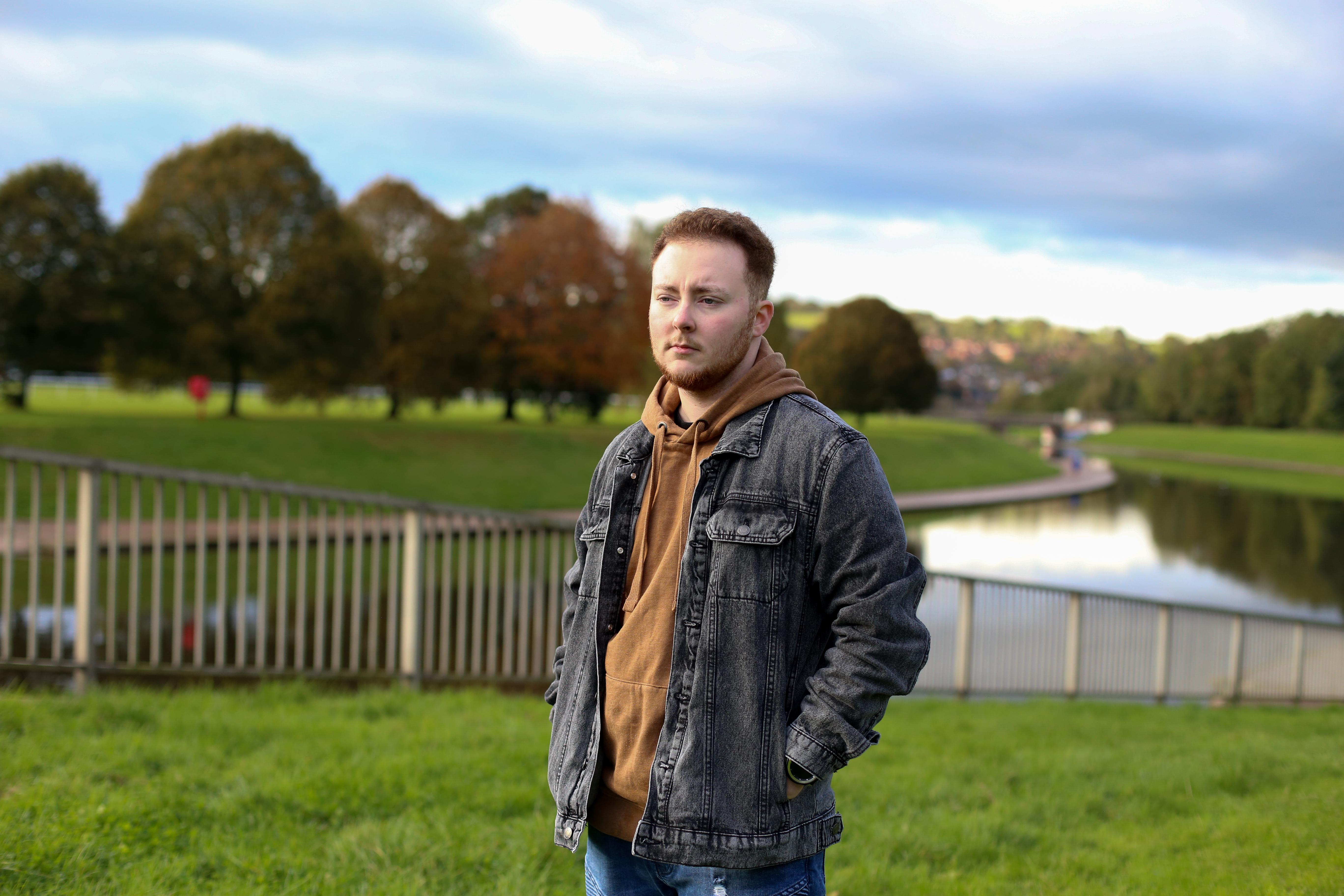 Trans man Jack Furlong standing in a field