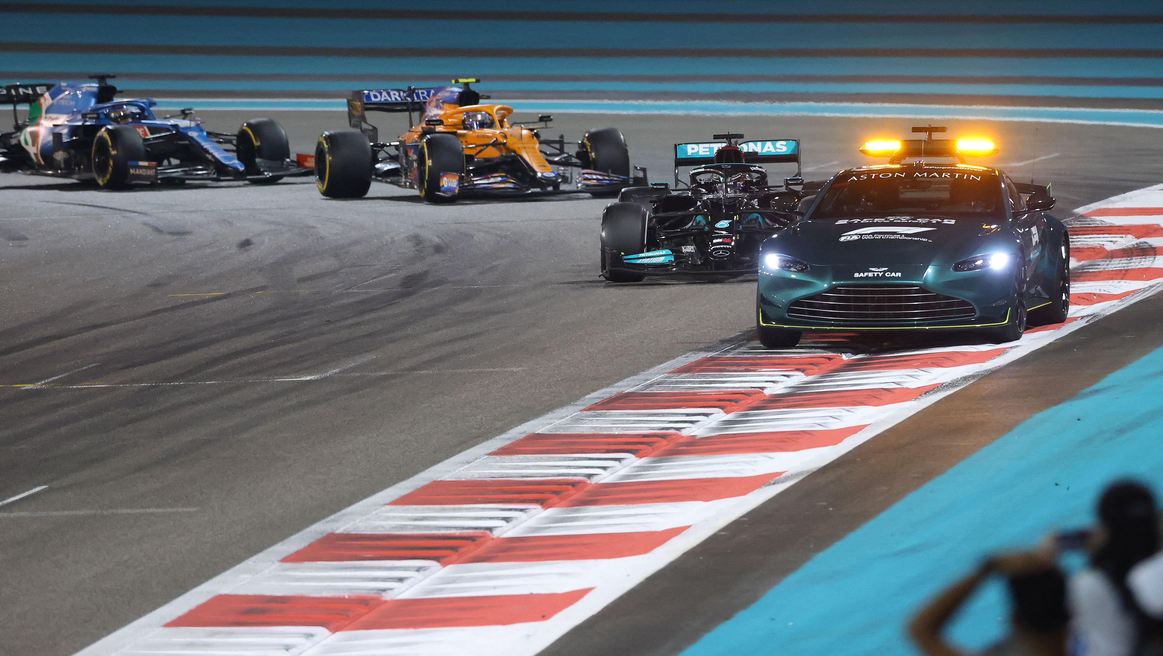 Mercedes' Lewis Hamilton drives behind the safety car, followed by five lapped cars and Verstappen. Photo: Giuseppe CACACE / AFP