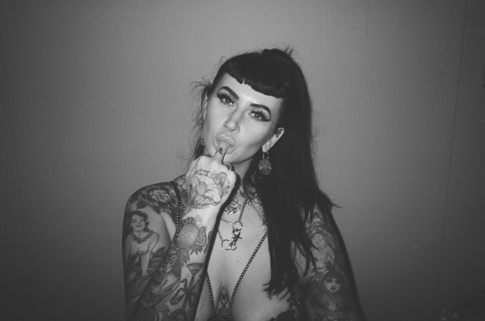 A person stares into the camera sucking their middle finger.