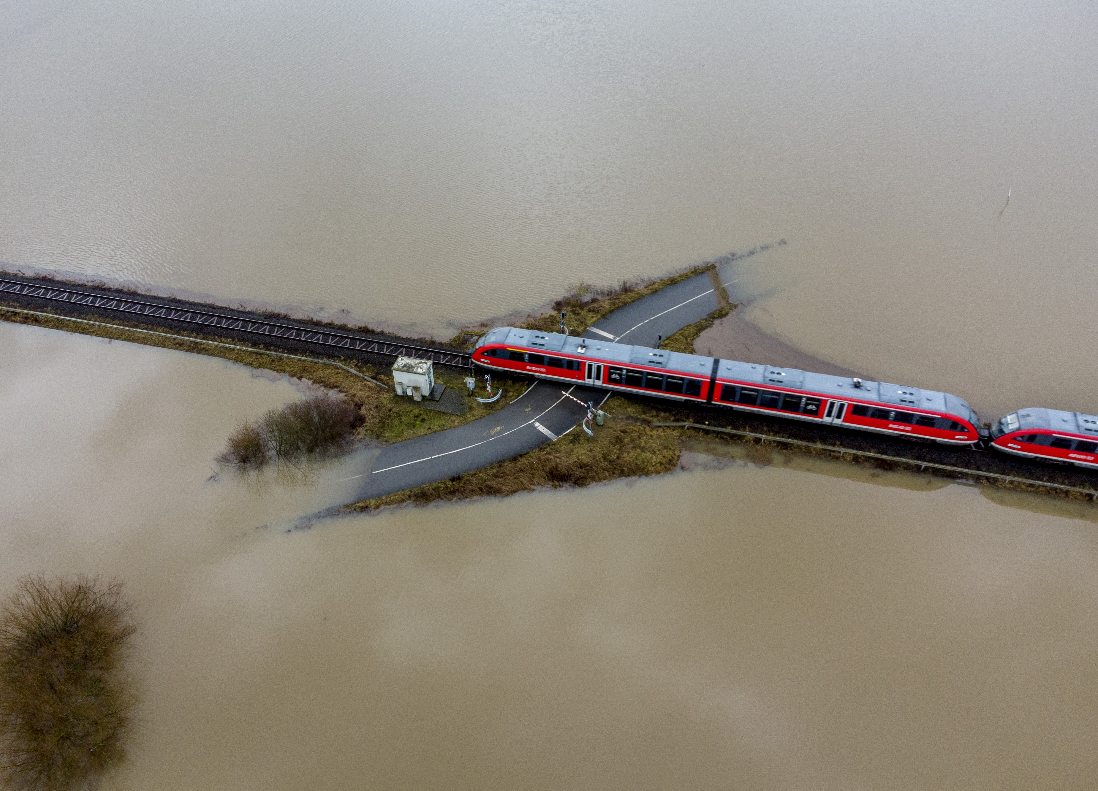 Un treno passa in una zona alluvionata della città di Nidderau vicono a Francoforte, in Germania. Foto: AP Photo/Michael Probst.