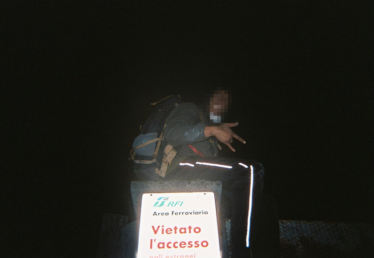 GifGas, trains, Belgium - Photo of a man with a pixellated face sat atop a train carriage in the dark.