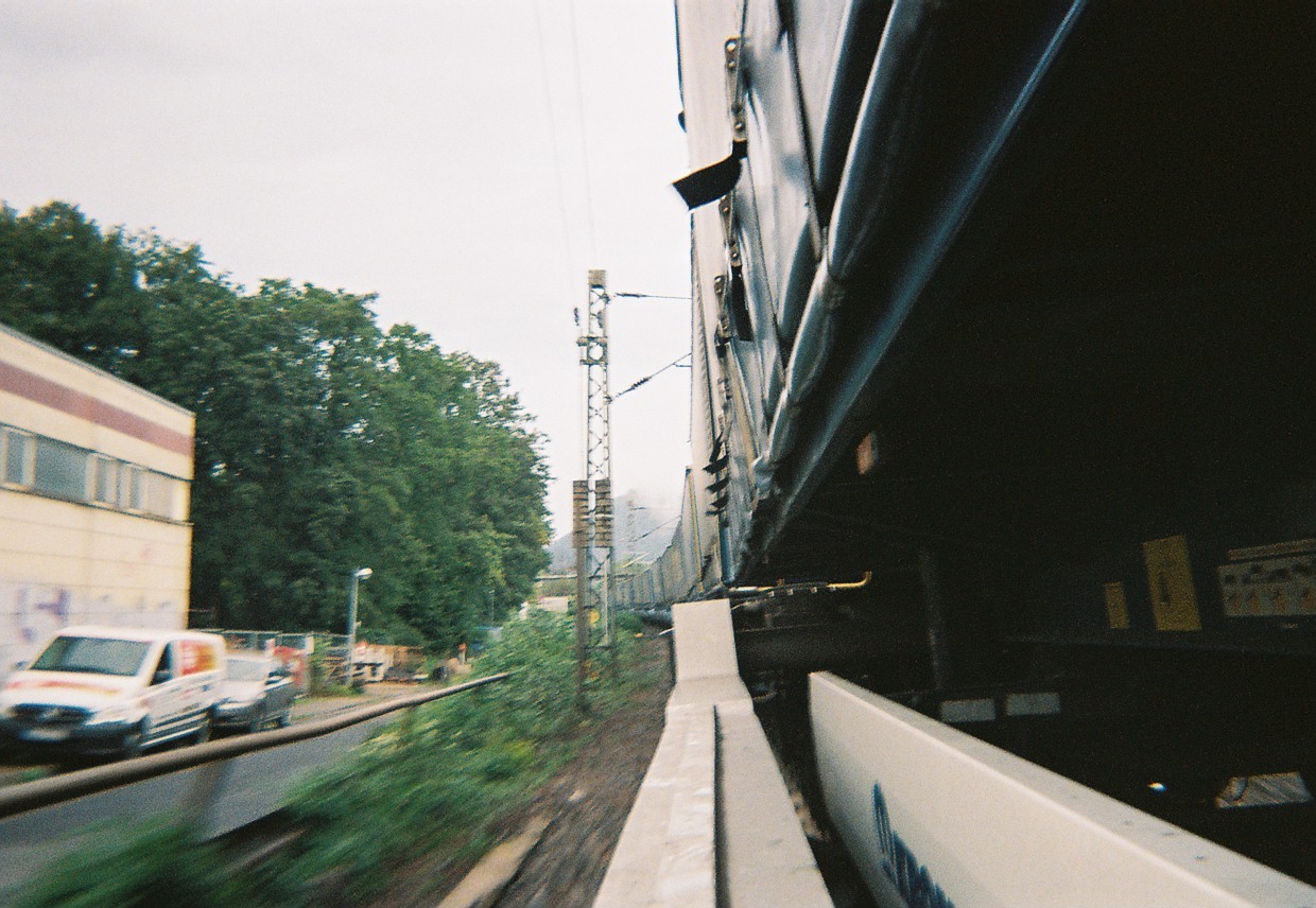 GifGas, trains, Belgium - Hazy photo of a train track taken from the side of a freight train.