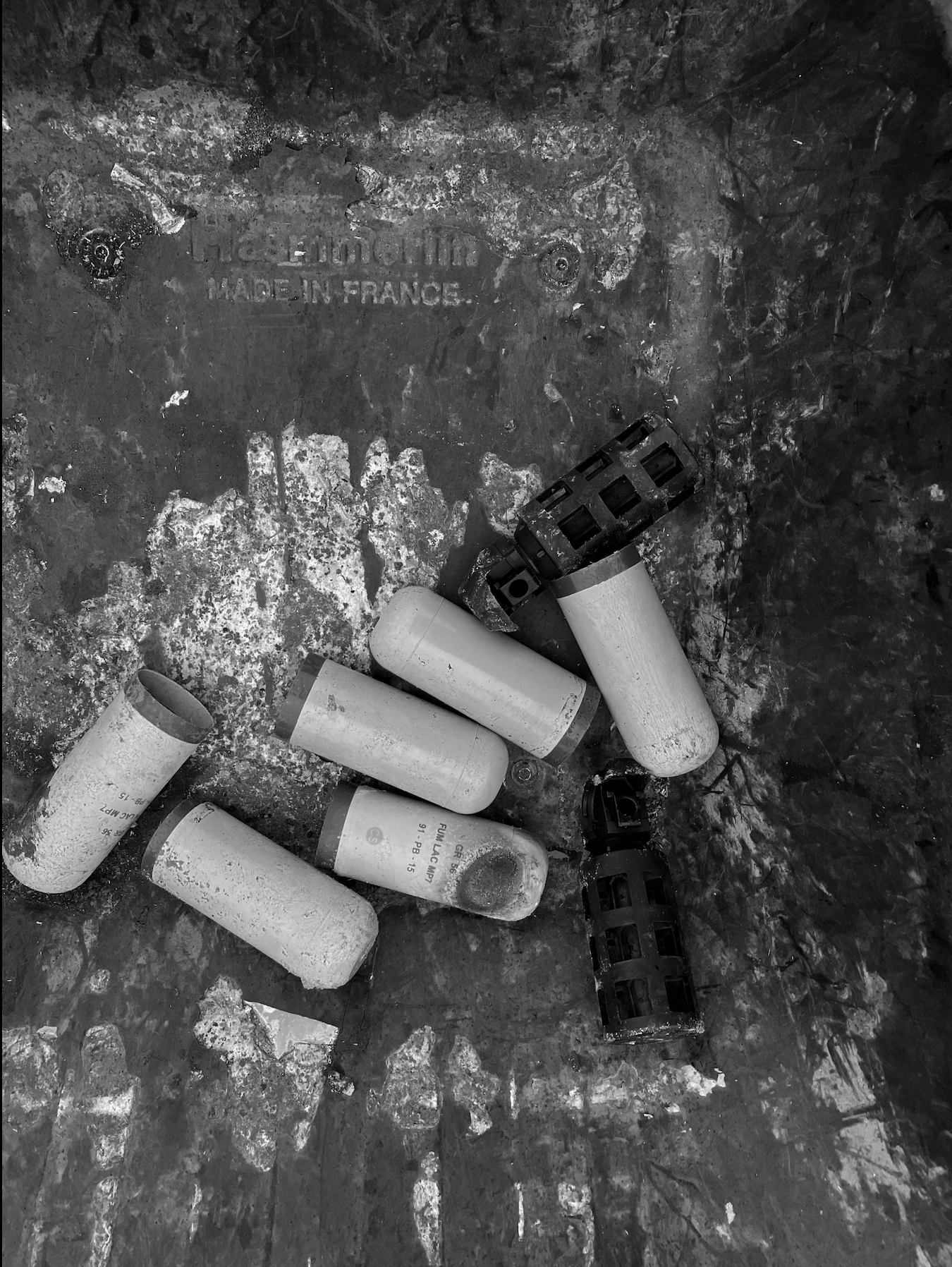 Calais, refugee camps - Black and white photo of the empty shells of tear gas grenades.