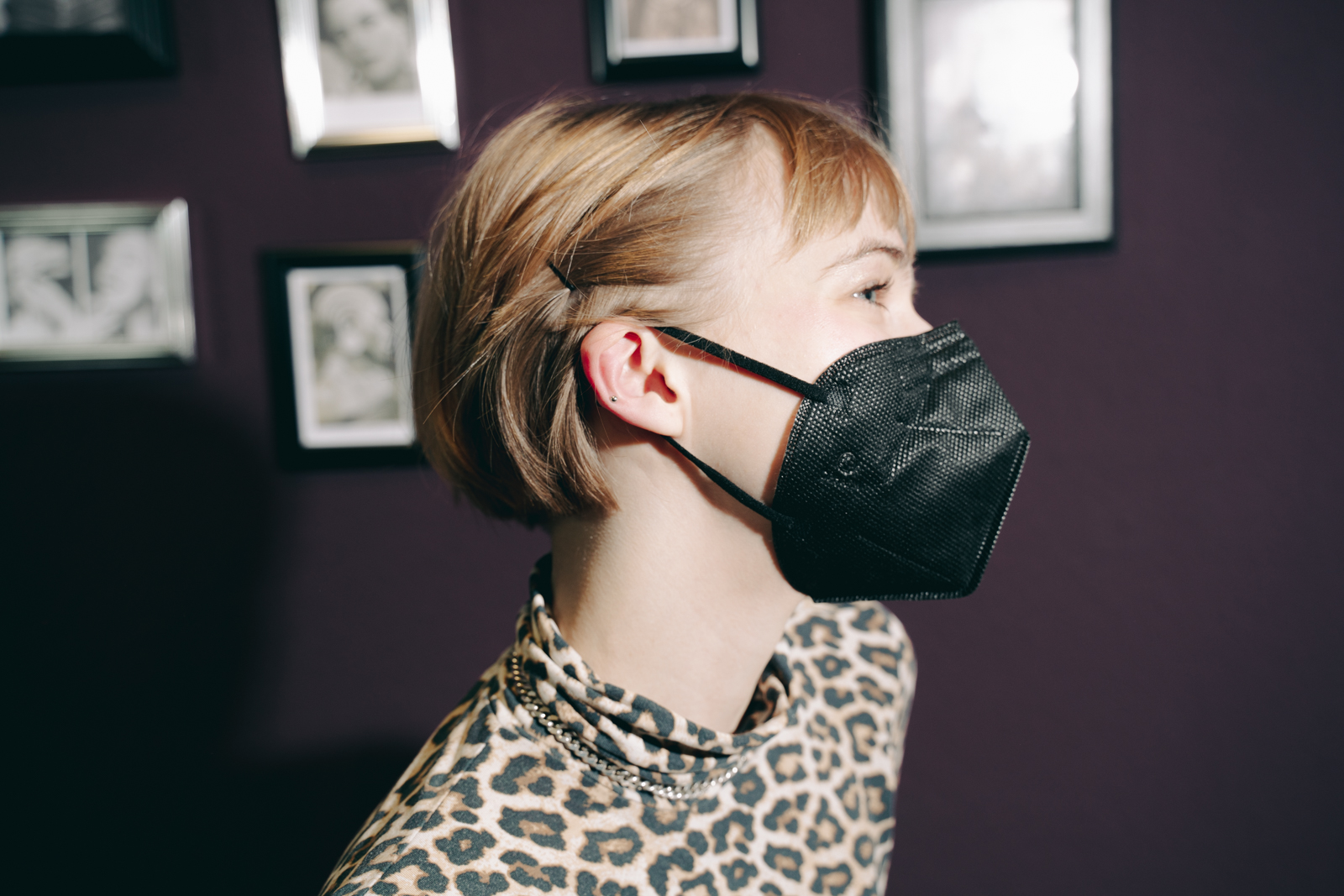 Die Autorin schaut auf nach links, ihre Haare werden mit einer Klammer zurückgehalten, um das Piercing an ihrem Ohr zu zeigen.