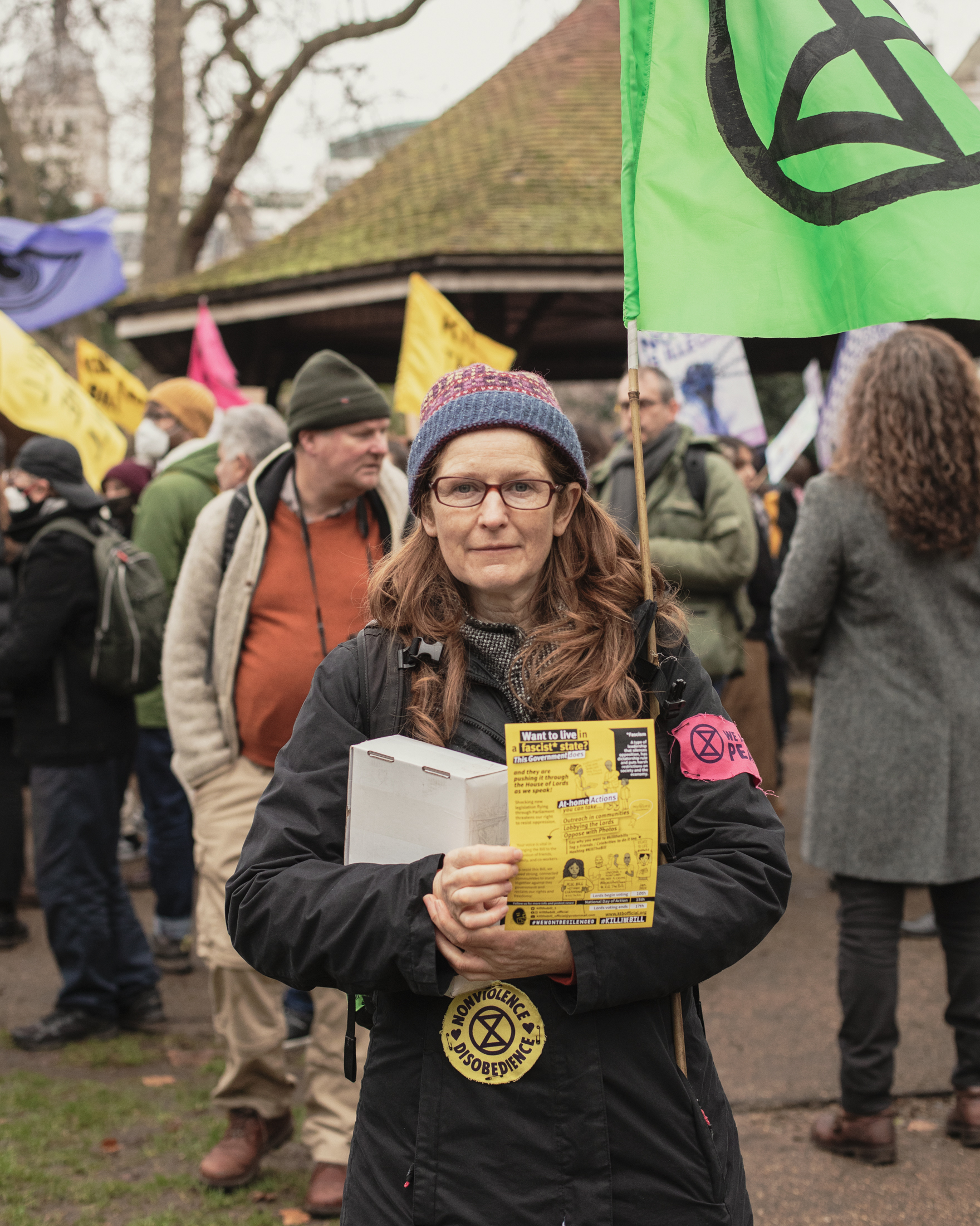 Kill the Bill protester Zoe standing and holding an XR flag.