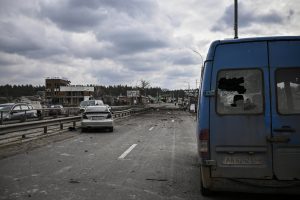 Des voitures abandonnées sont photographiées sur un pont détruit alors que les gens fuient la ville d'Irpin
