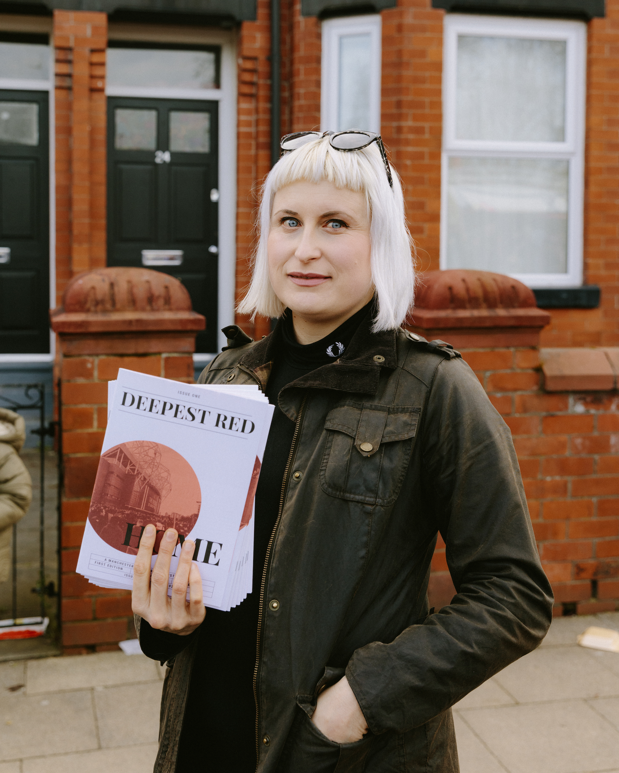 Manchester United supporter Carly Vandella, editor of Deepest Red, holds up copies of her fanzine