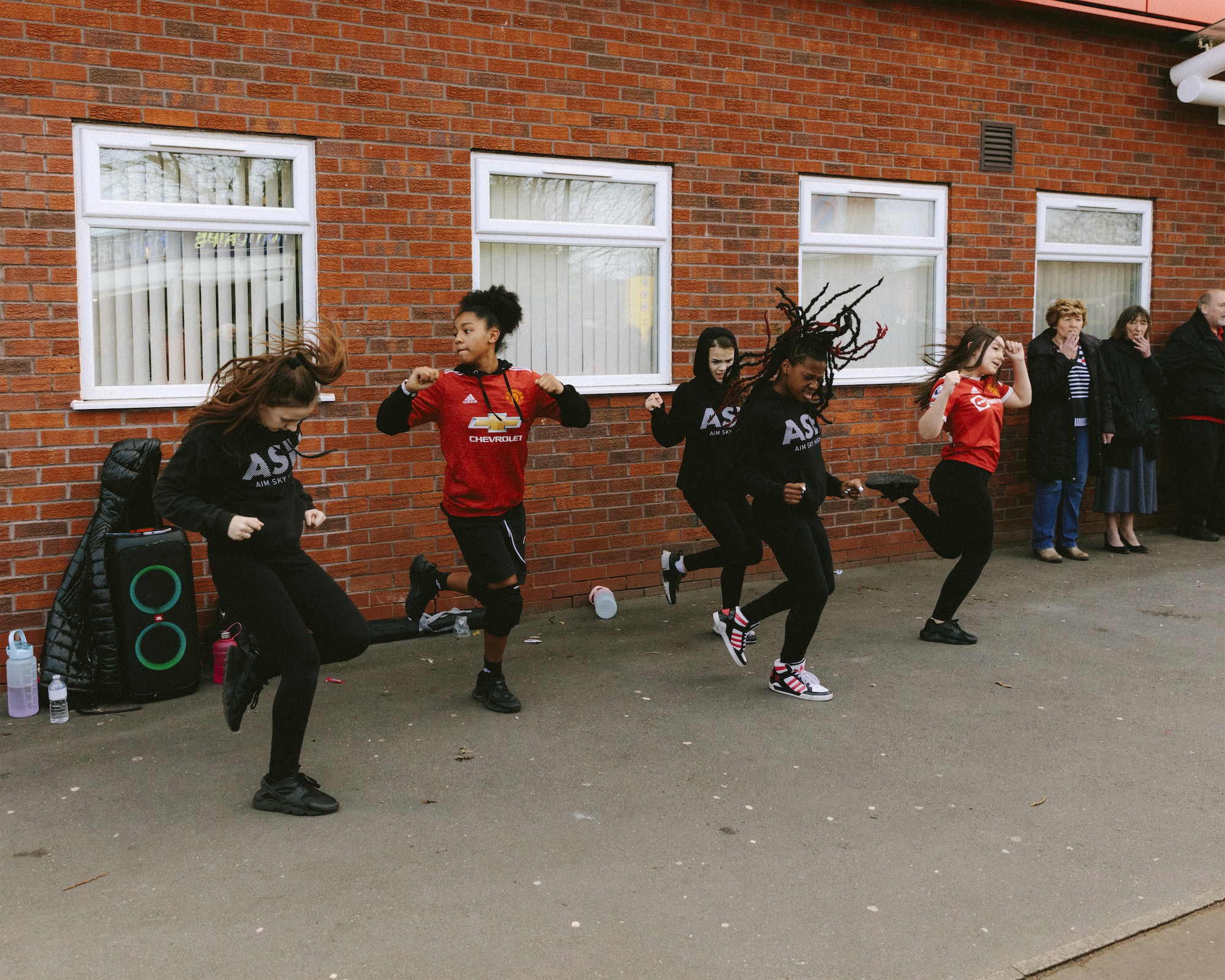 Kids perform a street dance near the Manchester United ground