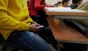 Foto ilustrasi lelaki mengecek ponsel di dalam kelas
