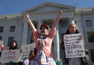Demonstrators hold signs as they stage a protest in favor of abortion rights on the steps on March 08, 2022 in Berkeley, California.​