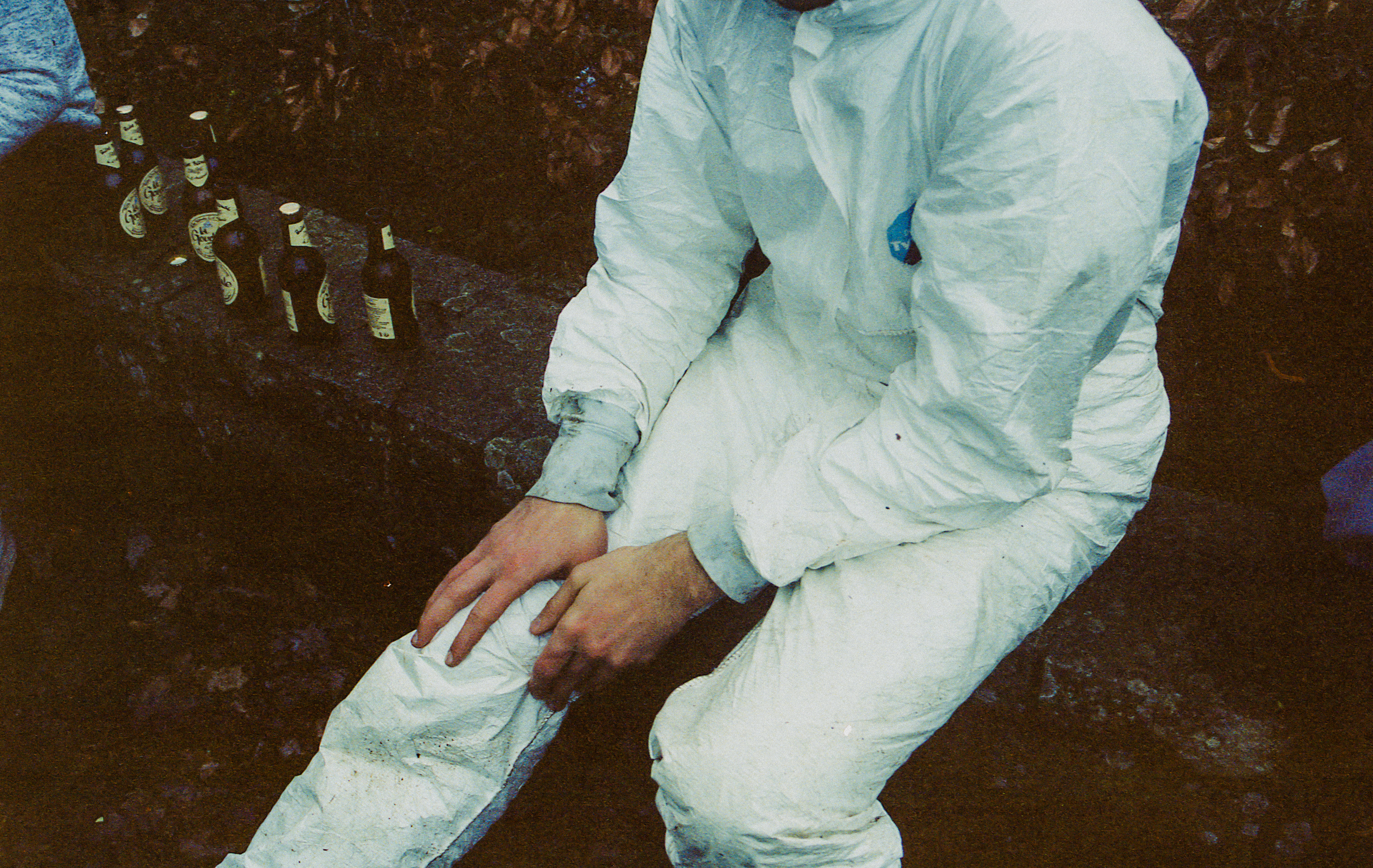 Mushary, France, hobbies – Photograph of a man in a white boiler suit clutching his knee.