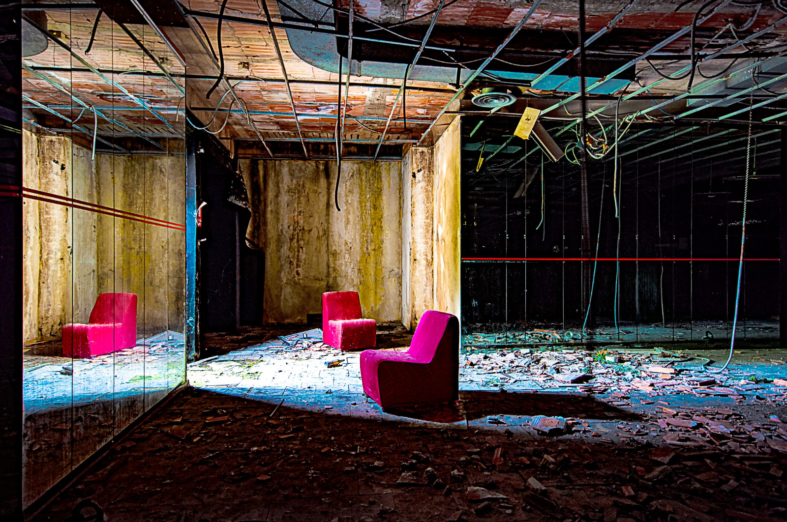 Italian Club Urbex, Woodpecker – large mirrored space with cables falling from the ceiling and two red velvety chairs.