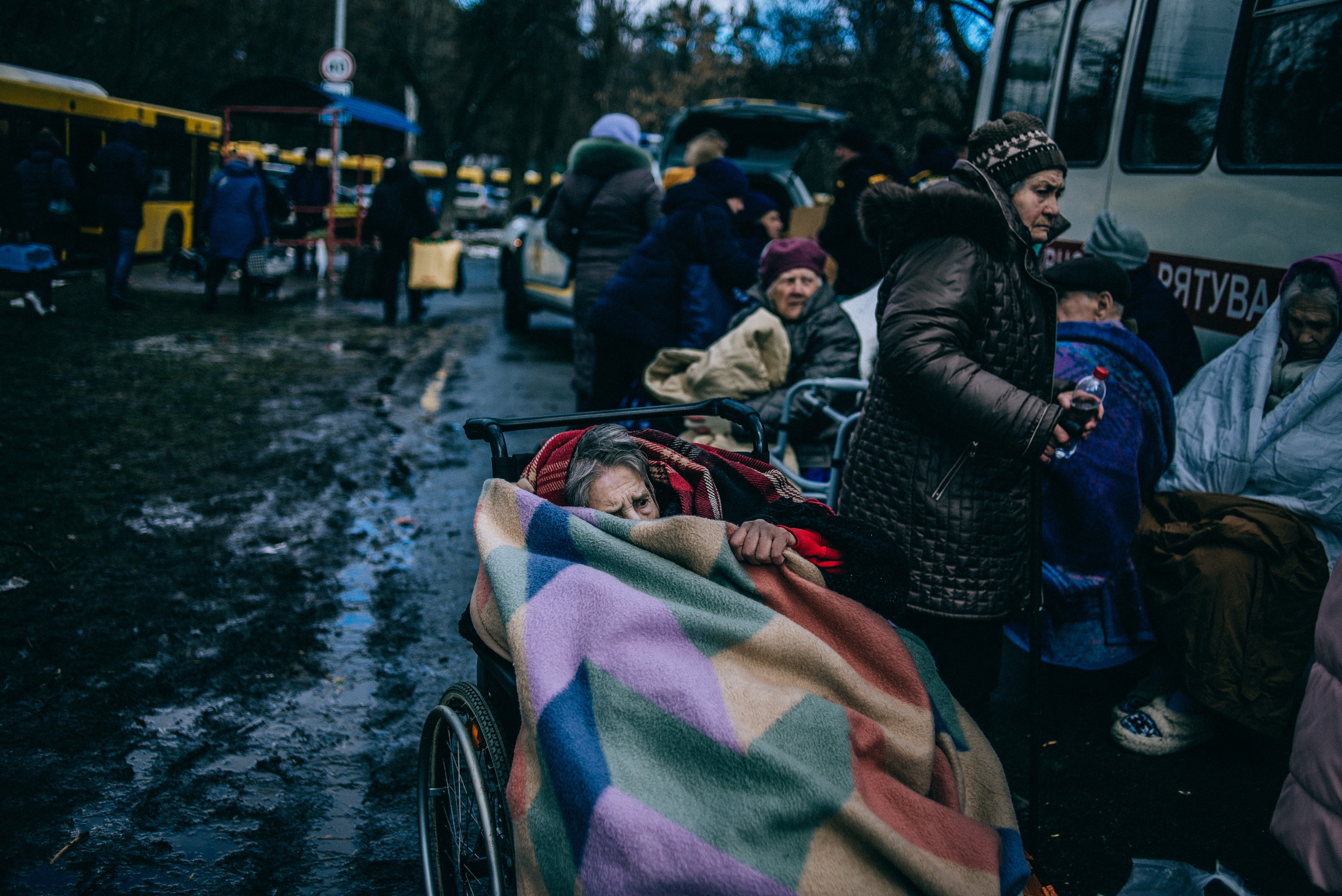 O femeie în vârstă se adăpostește sub o pătură după ce a fost evacuată din Irpin, în apropiere de Kyiv, luna trecută