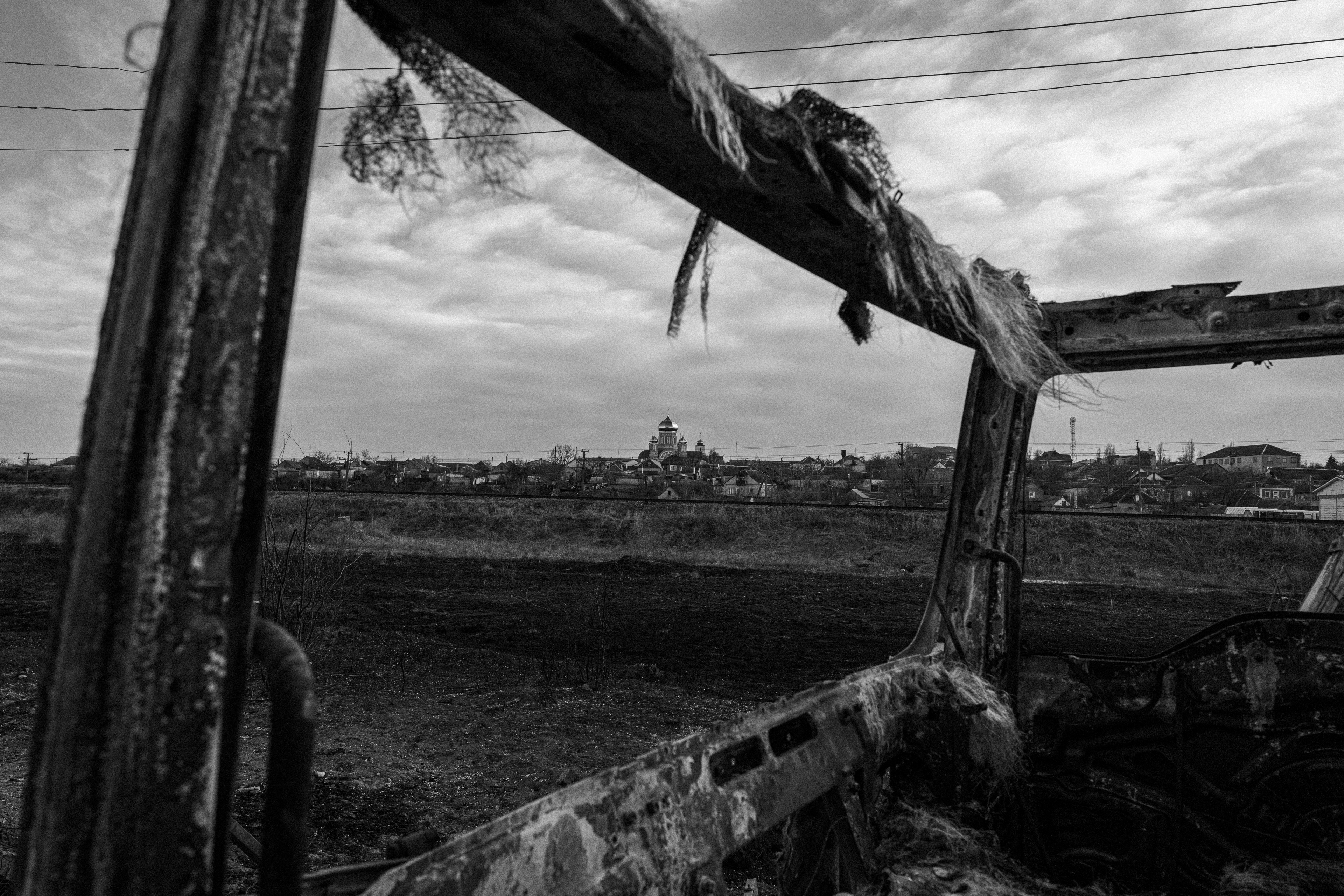 The outskirts of Mykolaiv, seen through the remains of a destroyed truck.