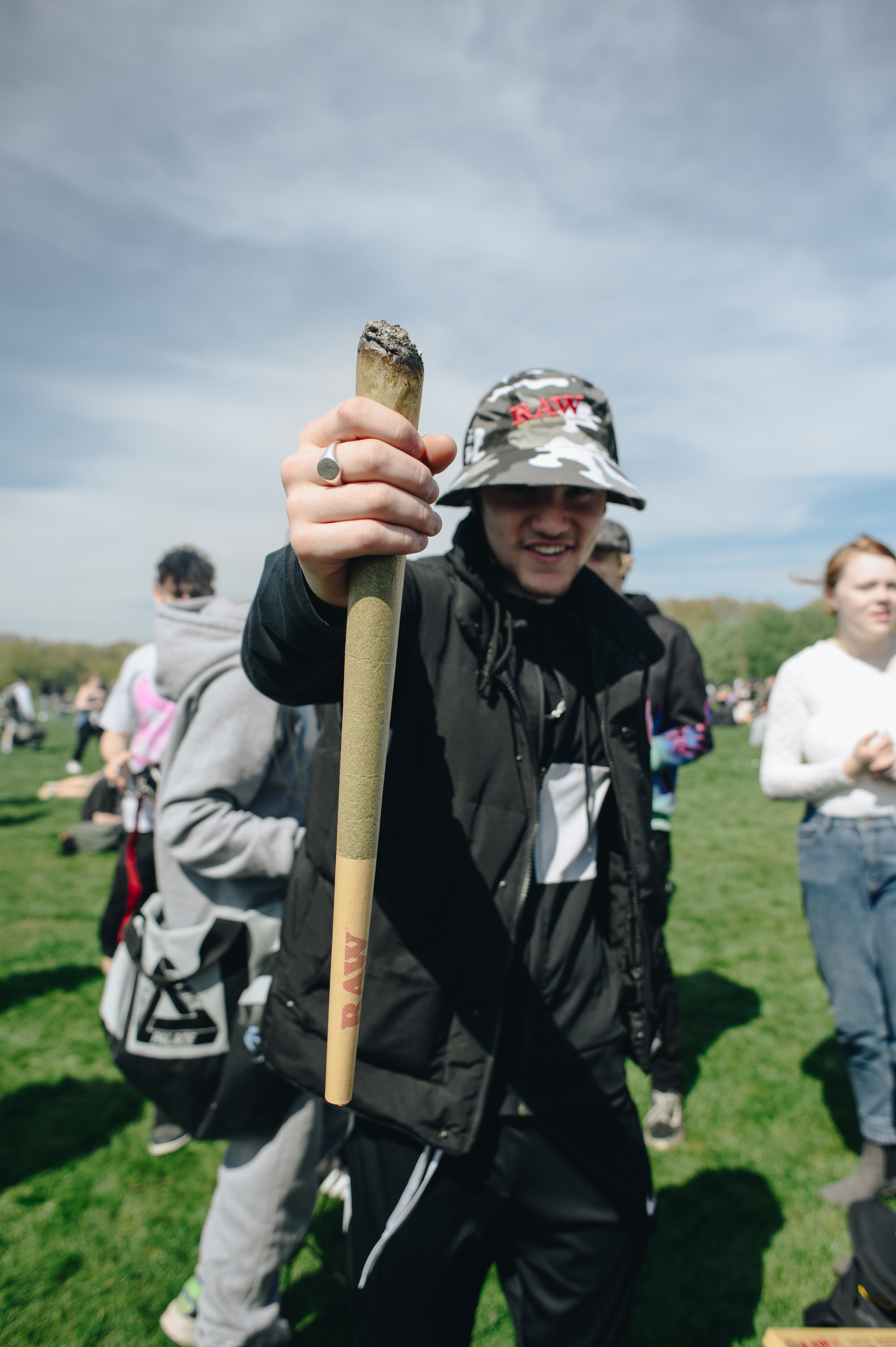 A person in a bucket hat holding a giant spliff at 4/20 protest in London Hyde Park