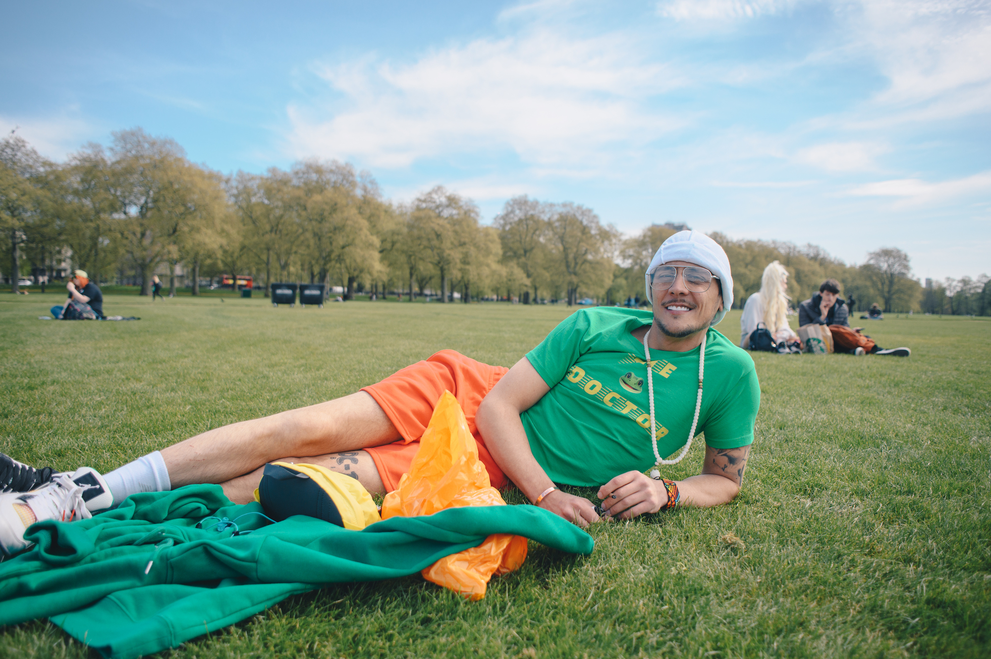 A person in Jamaica flag colours lying on grass at London's 4/20 protest in Hyde Park