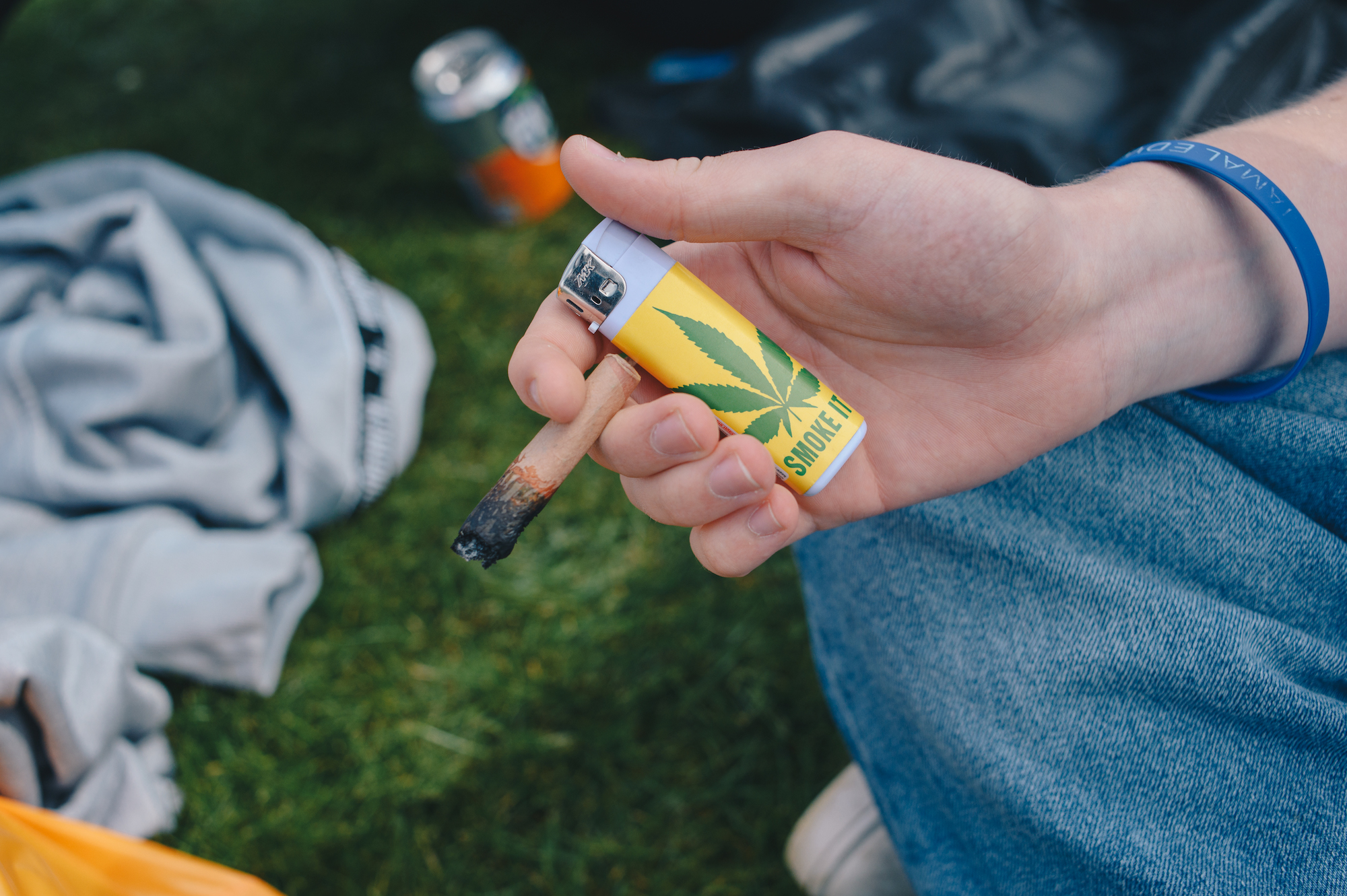 A person holding a spliff and a lighter saying