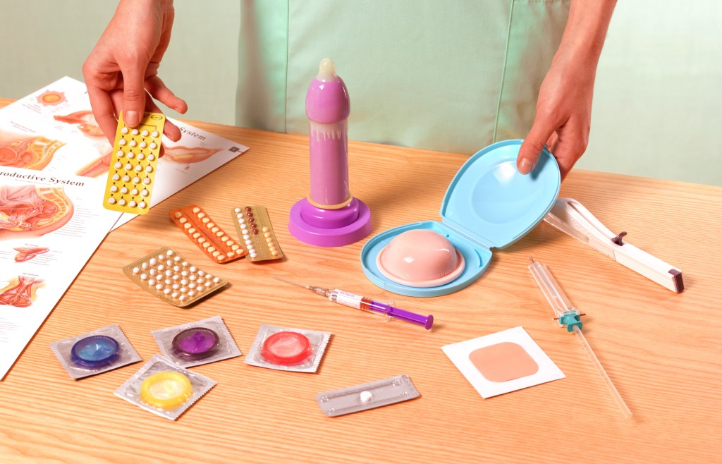 School nurse delivering sex education in front of table of contraception