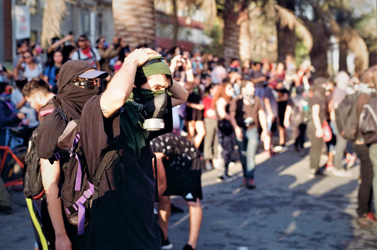 Chile protests – Protesters looking at a clash from a safe distance.