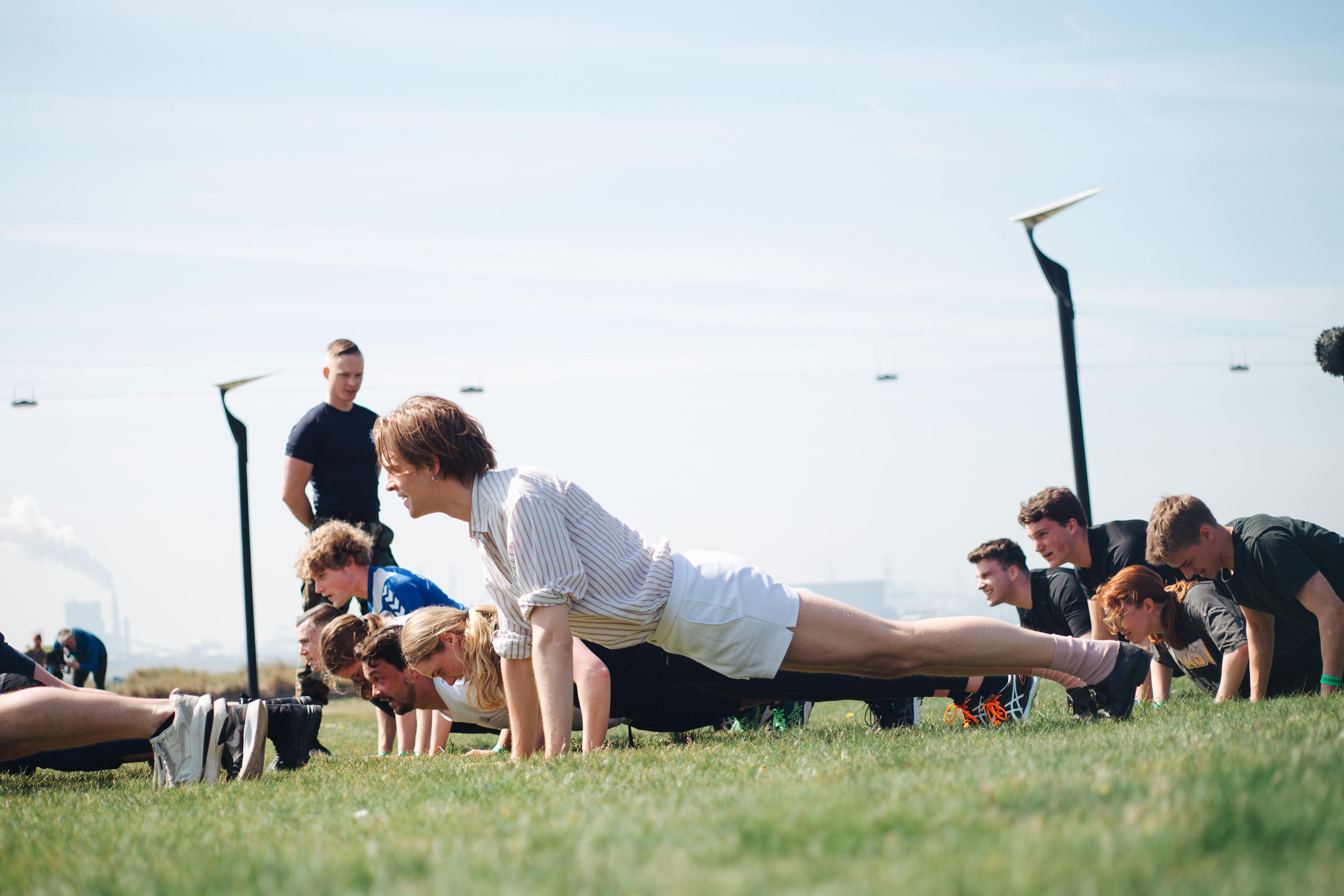 Army recruitment, Fort 1881 – The author doing push ups on a grassy field together with some other young men and women.