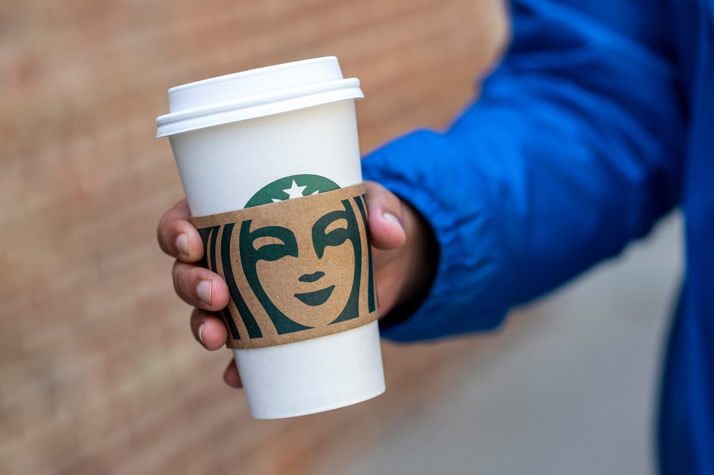 A pedestrian carries a Starbucks branded cup in San Francisco, California, U.S., on Thursday, April 28, 2022.